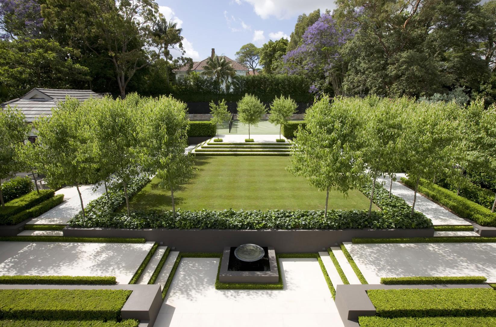 Garden with lawn area and water feature flanked by stairs